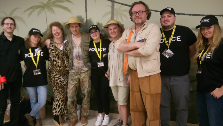 L'équipe 10Torsions pose en tee-shirts Police et en costumes d'explorateurs devant un décor de jungle