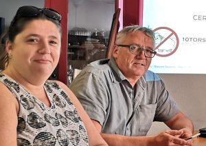 Deux participants d’un atelier discussion 10Torsions chez Cerfrance, souriants autour de la table devant la diapositive projetée