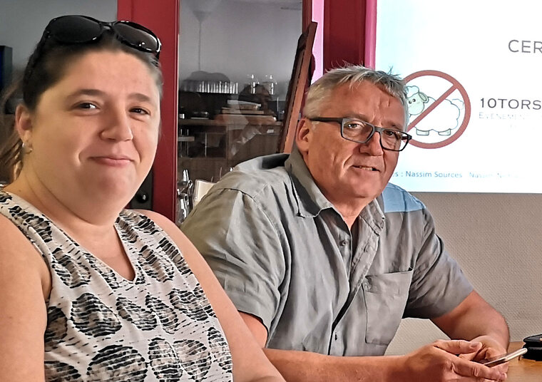 Deux participants d’un atelier discussion 10Torsions chez Cerfrance, souriants autour de la table devant la diapositive projetée