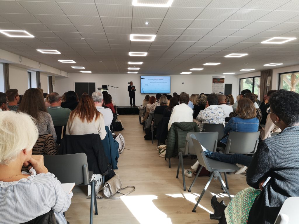Conférence 10Torsions devant une salle pleine, l’intervenant au micro sur l’estrade face à une centaine de participants