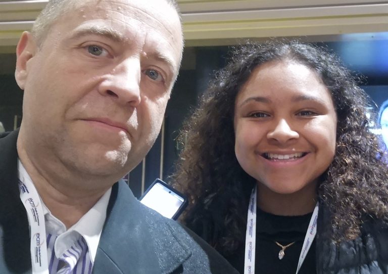 Selfie de deux membres de l’équipe 10Torsions, badges au cou, sur un salon